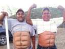two fat guys at a fence looking like a sixpack
